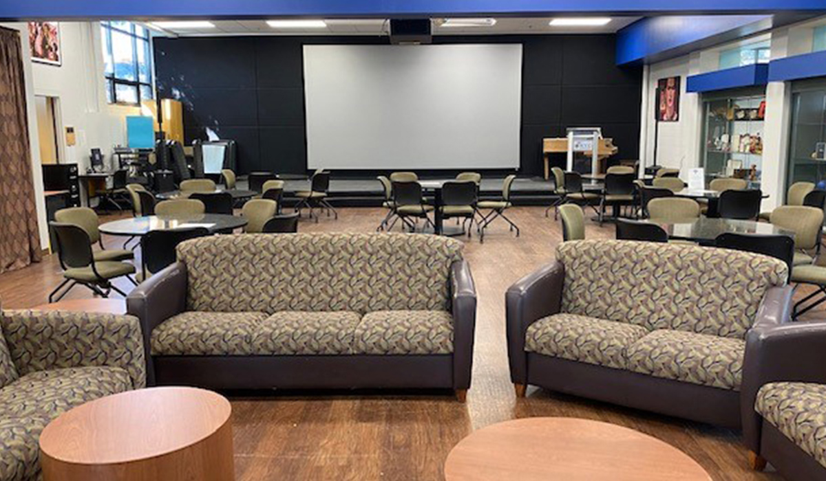 Van Tassell Center student lounge with couches, tables, and a stage.