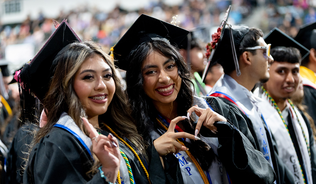 Two female graduates at graduation ceremony.
