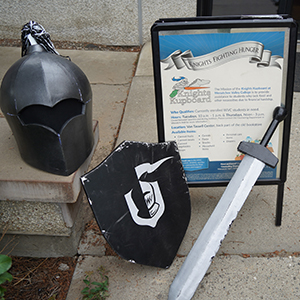 A sign for the Knights Kupboard food pantry is surrounded by Knights mascot gear.