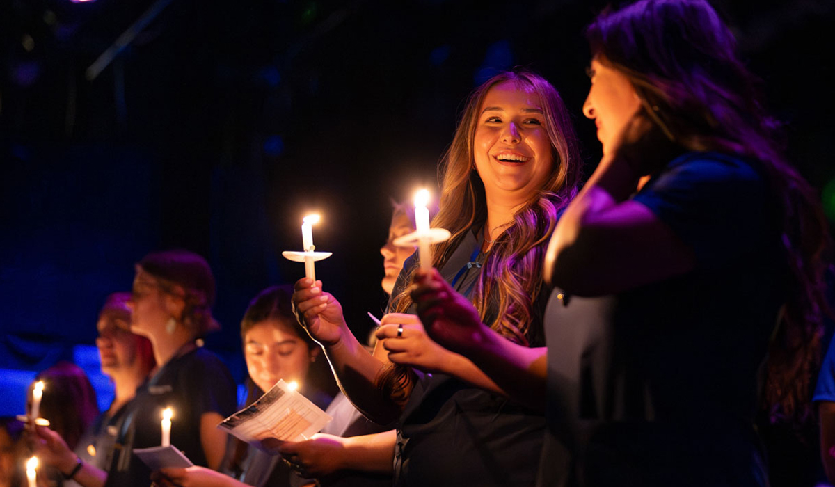 Two ADN nursing graduates holding candles during the pinning ceremony.