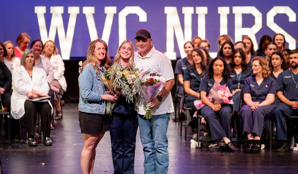 WVC nursing graduate posing with family members at pinning event