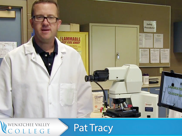 WVC Medical Laboratory Technology Director Pat Tracy, wearing a white lab coat, stands in the MLT lab.
