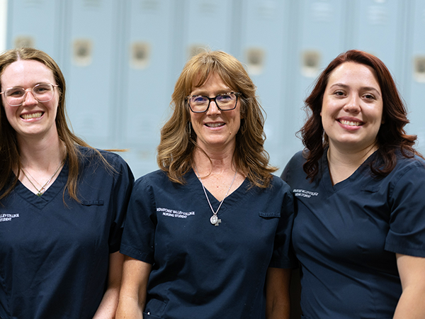 Three WVC nursing students stand together and smile at the camera.