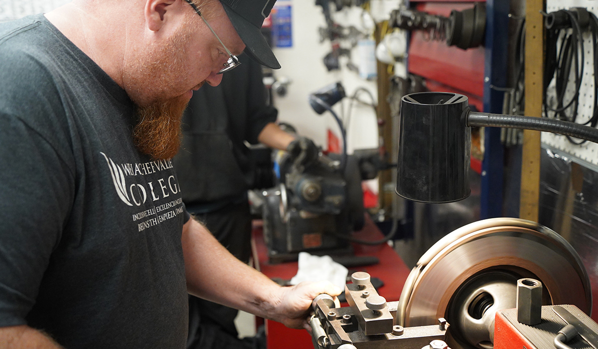A WVC student works on a brake pad.