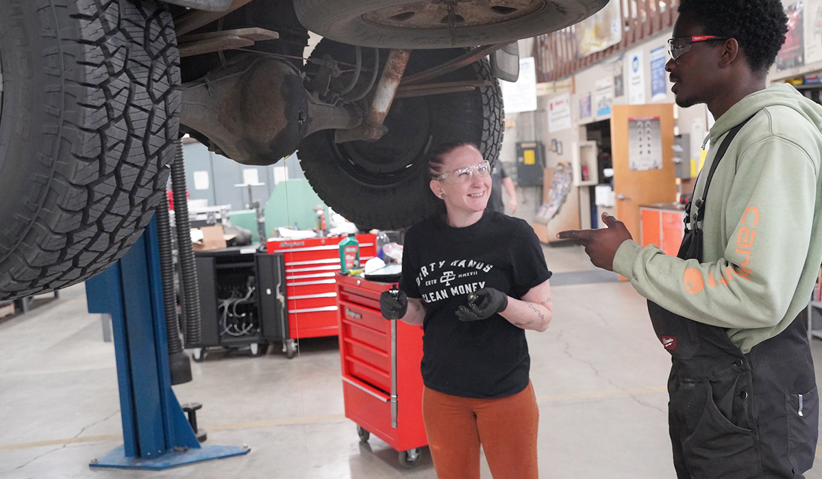 Two WVC auto tech students work beneath a pickup as the differential fluid drains.
