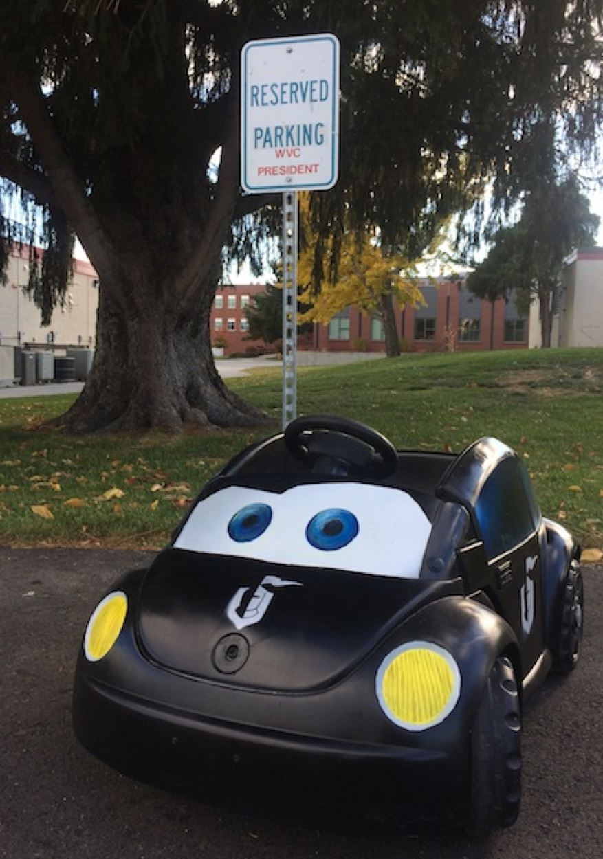 The Knight Bug car sits in a parking lot next to a Reserved Parking sign.