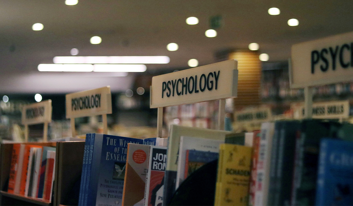 A row of psychology books on a shelf.