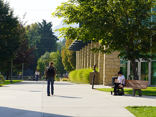 A couple of students walk down a concrete path in front of Wenatchi Hall on the WVC Wenatchee campus.