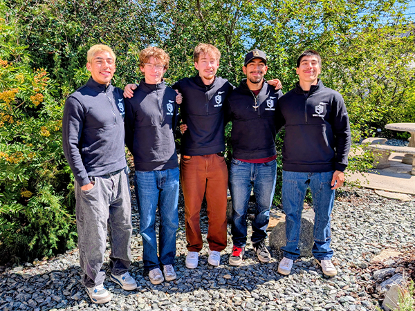 Five of the Community Engaged Knights members stand together in the WVC Omak Native Garden