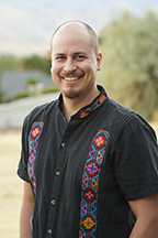 Portrait of Roberto Mendoza standing outside.