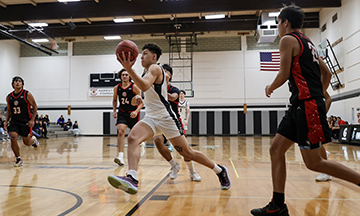A Knights basketball player makes a drive for the hoop.