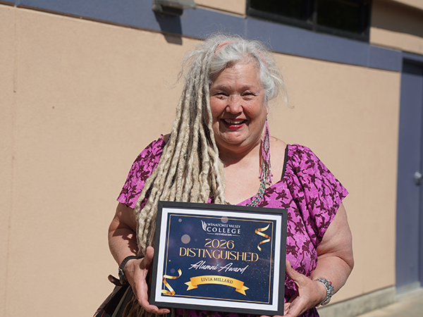 Livia Millard holds her WVC Foundation Distinguished Alumni Award plaque.