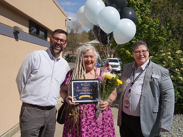 Foundation director Clint Strand and WVC Omak Dean Cal Cross stand on each side of Distinguished Alumni Award winner Livia Millard.